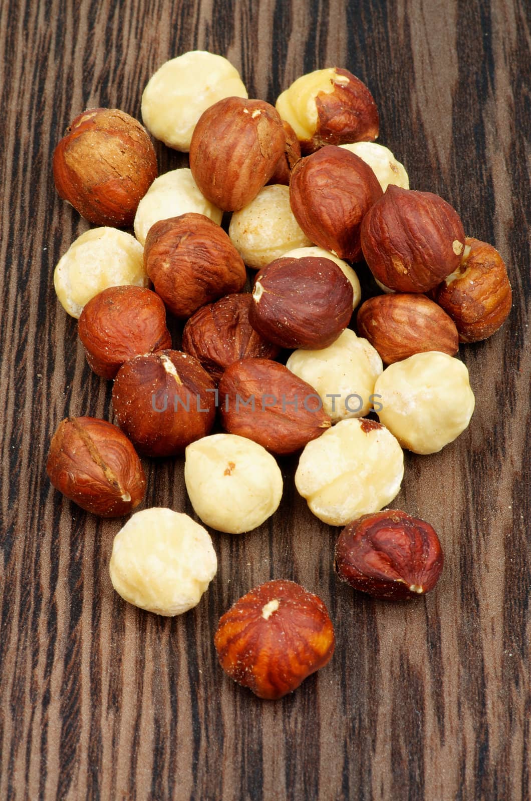 Pile of Perfect Dry Hazelnuts closeup on Dark Wood background