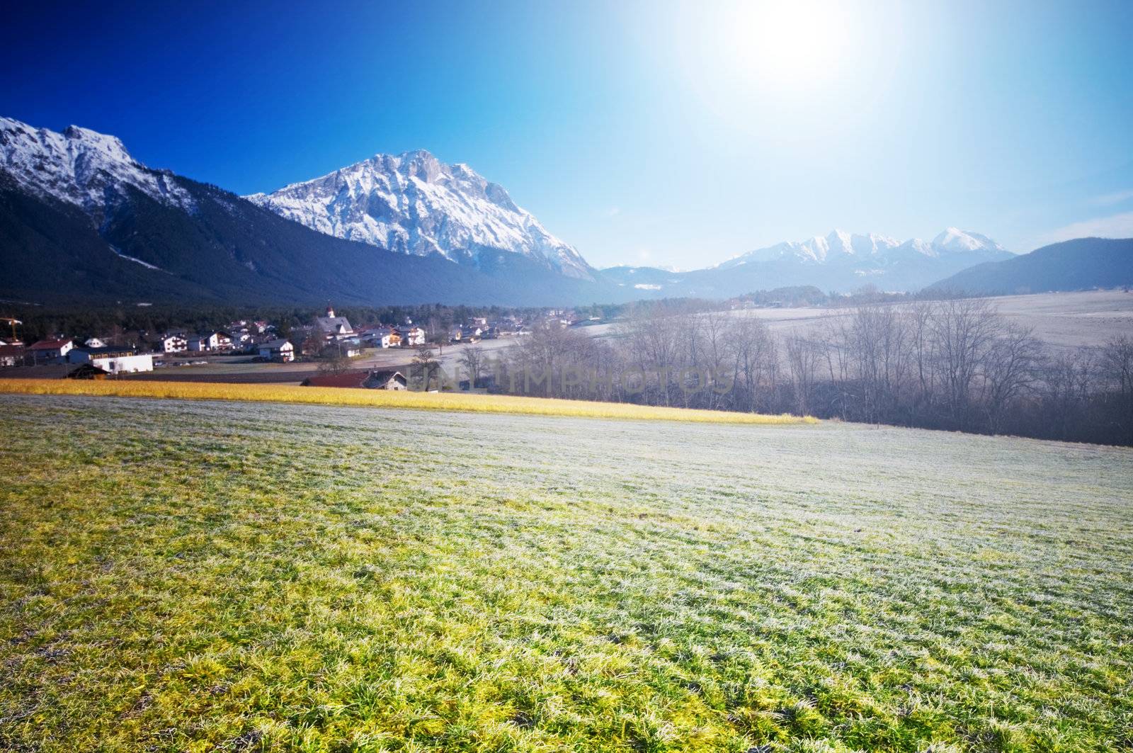 Spring Alpine landscape with blue sky and sun