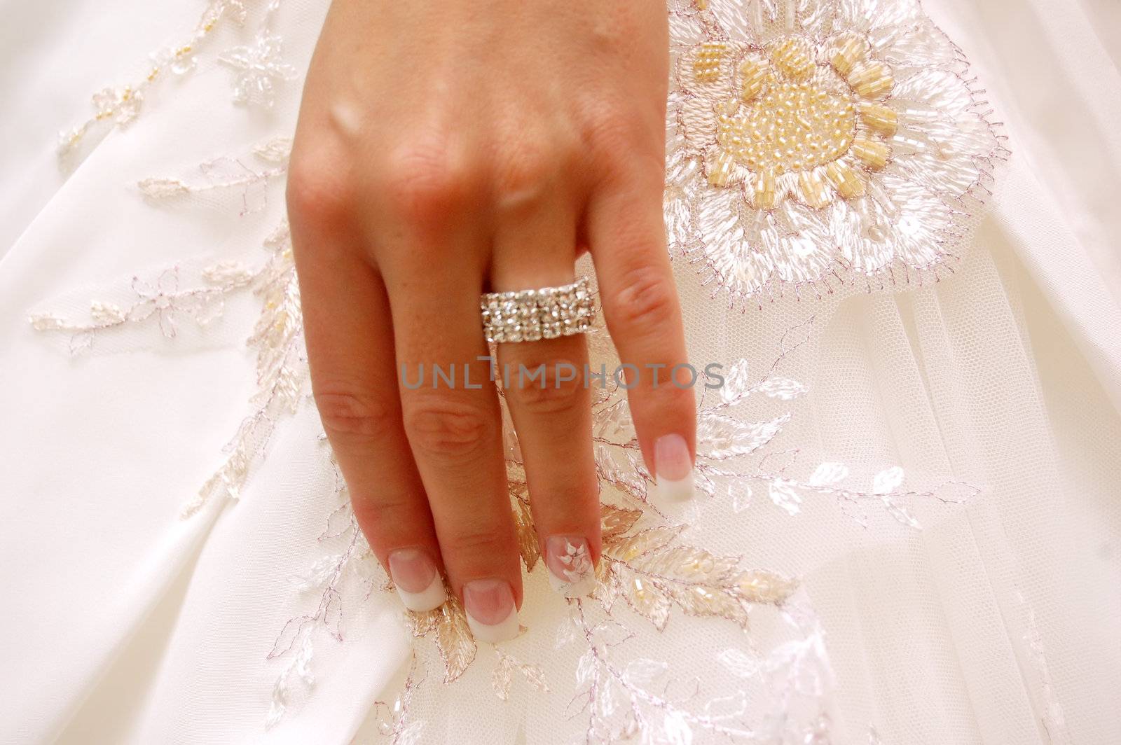 Wedding background. Bride's hand with ring on wedding gown