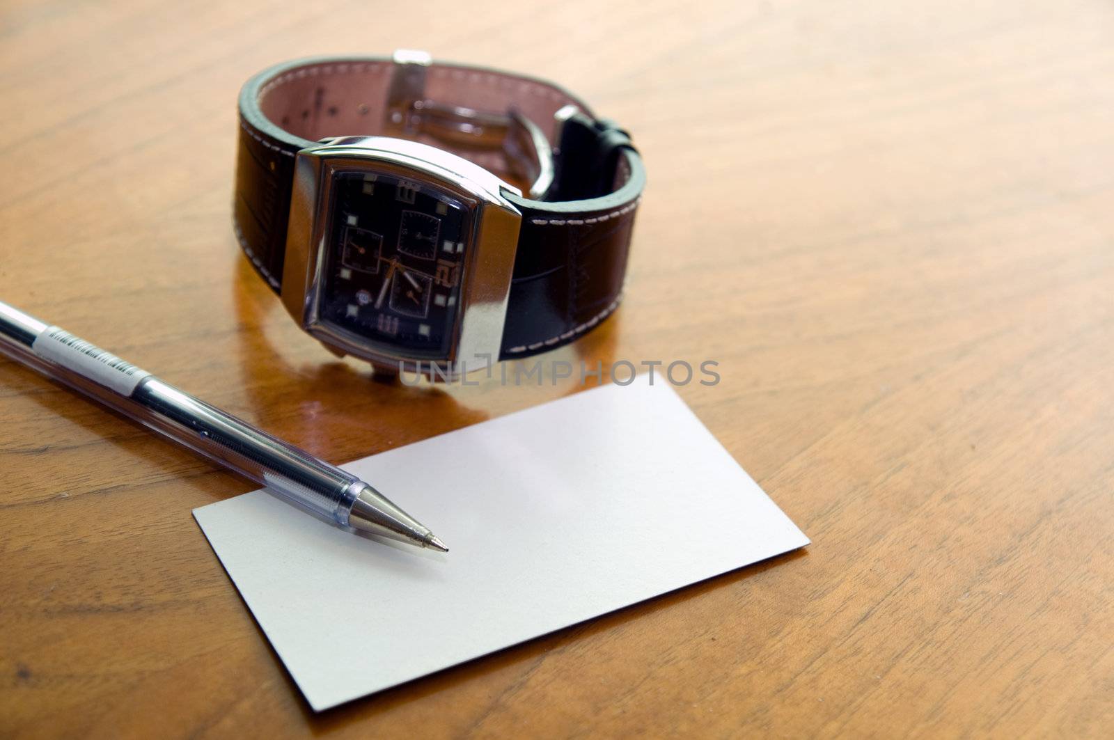 Modern business desk with watch, pen, business card