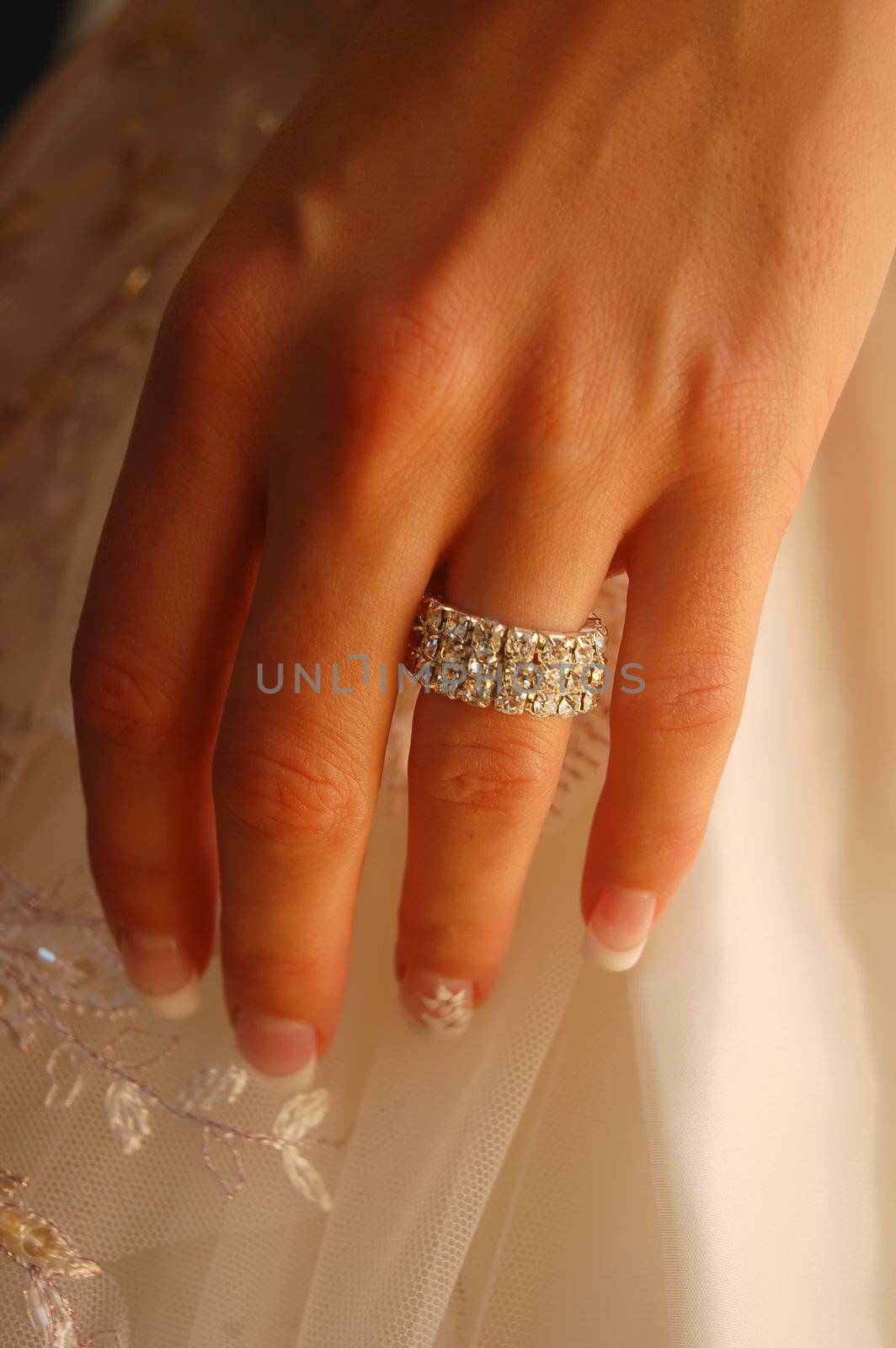 Wedding background. Bride's hand with ring on wedding gown