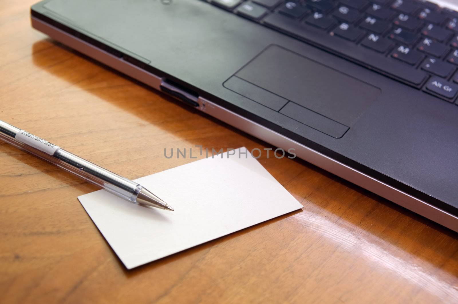 Modern business desk with laptop pen and business card