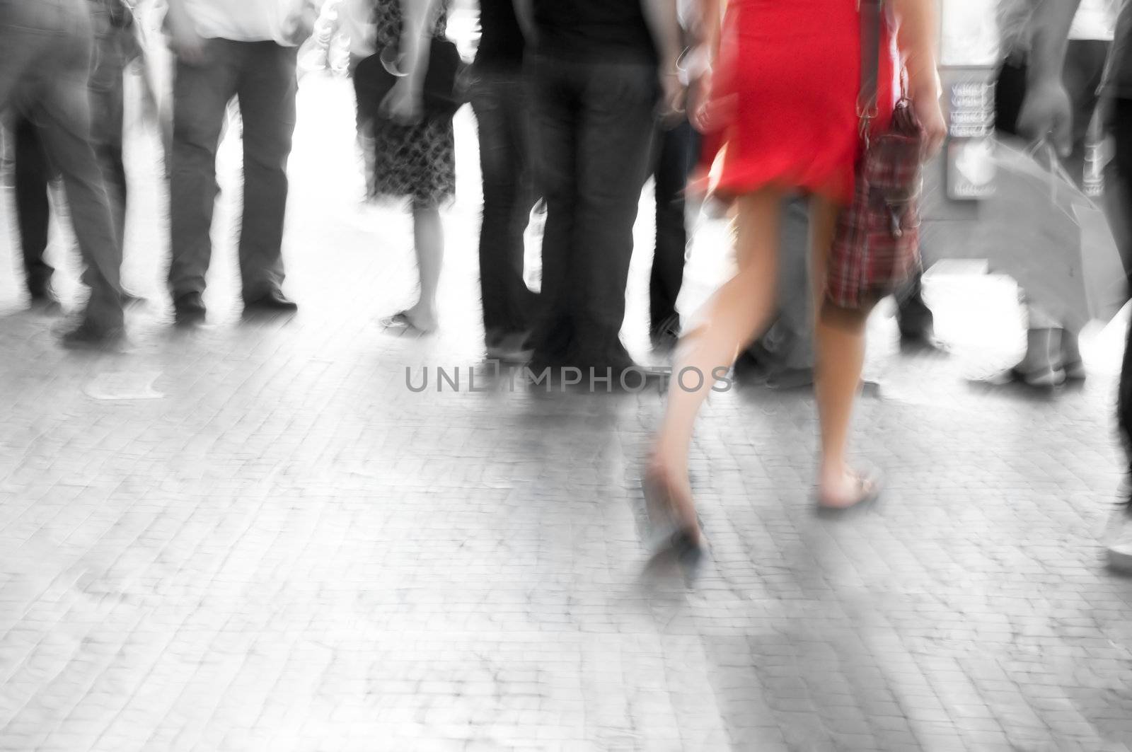 Busy big city street. Woman in red among black and white