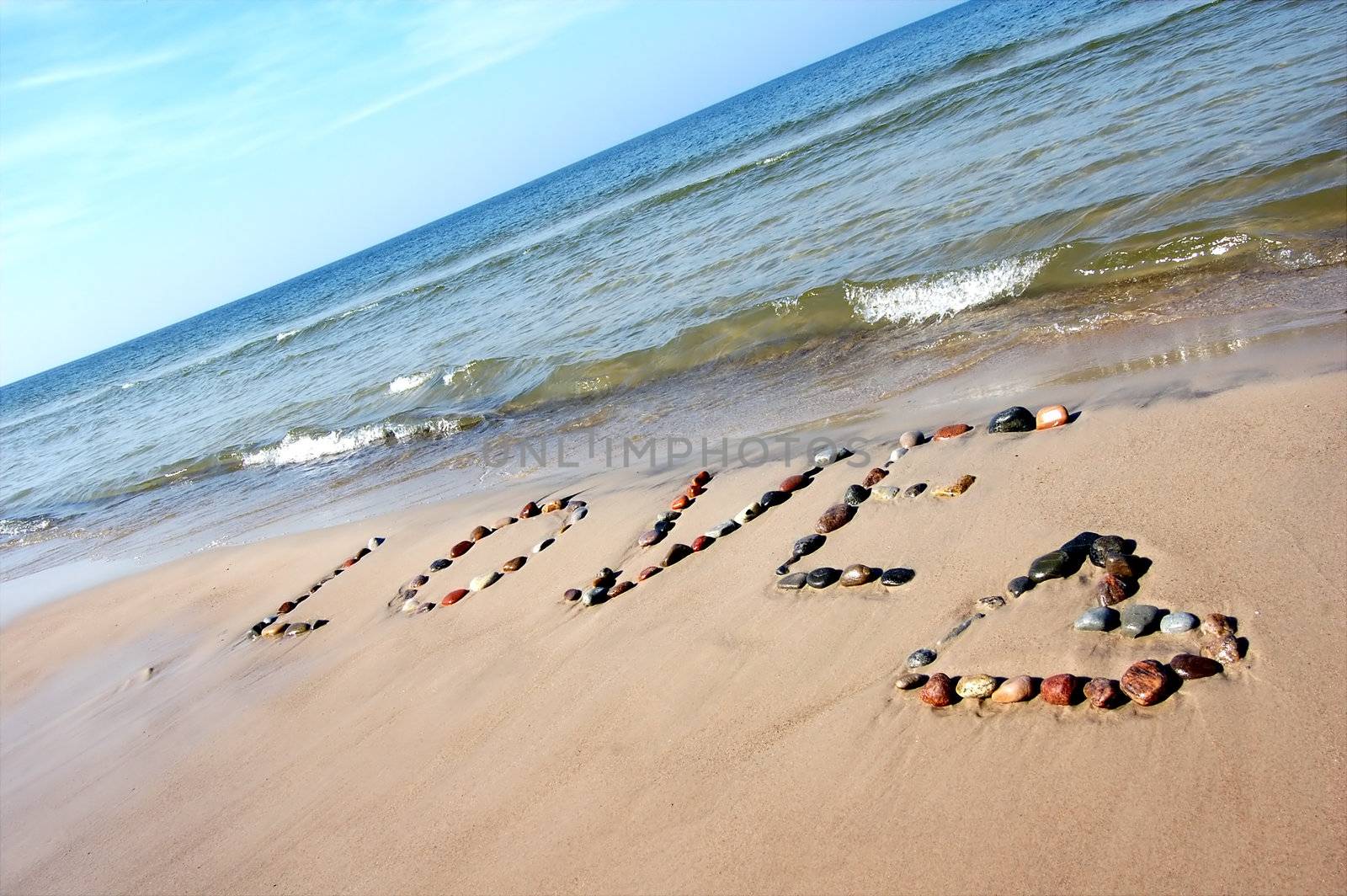 Word LOVE on beach sand, made from rocks