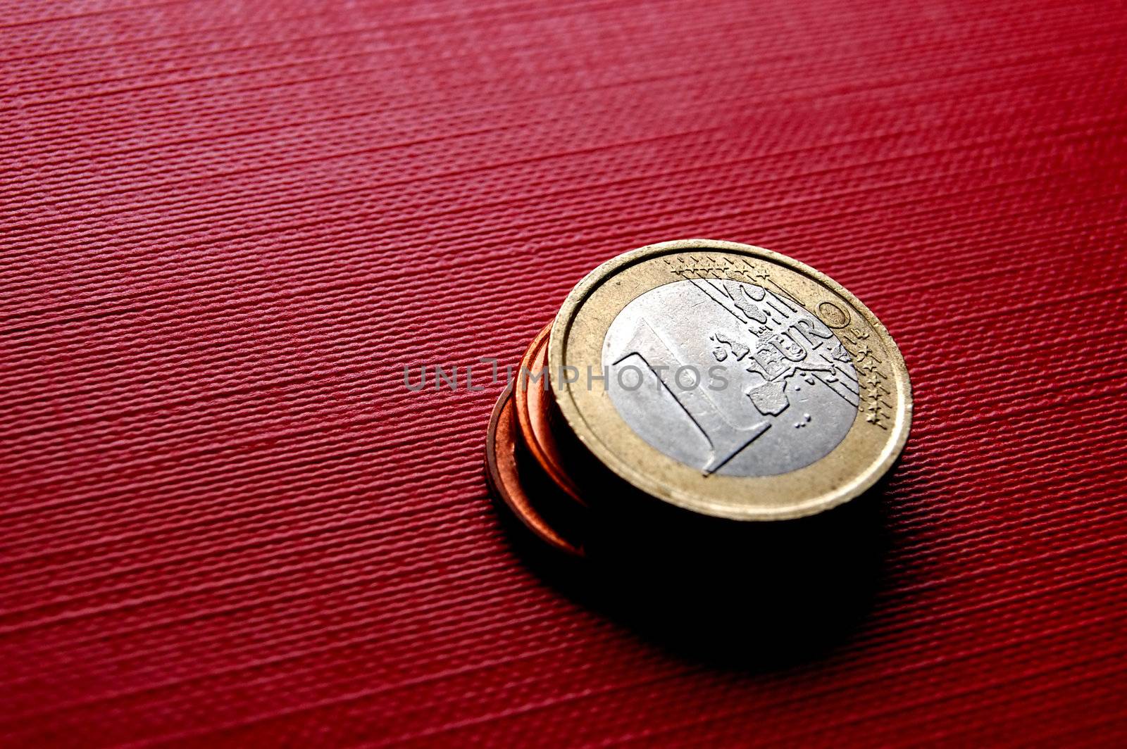 Euro coins on red surface