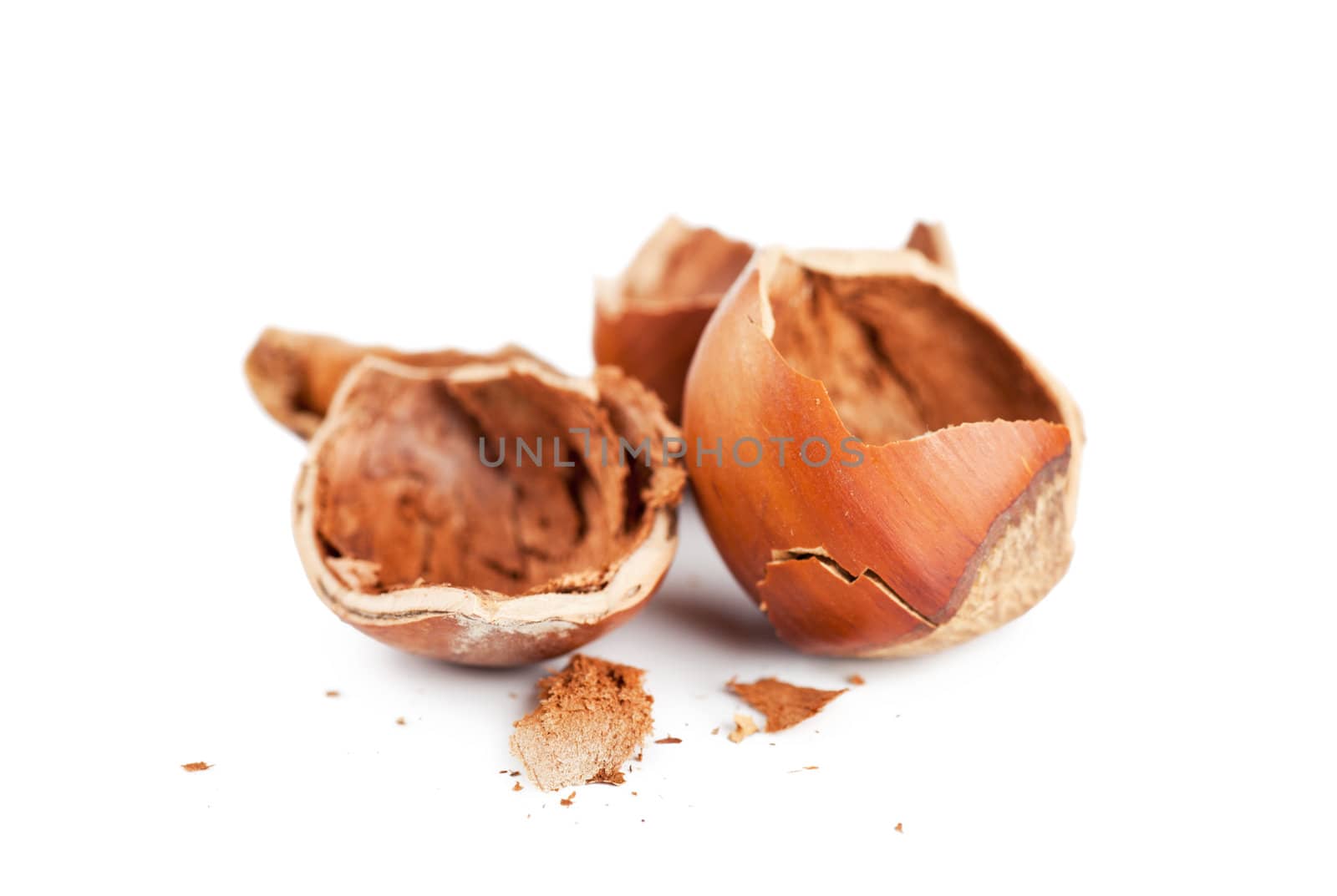 Closeup view of cracked hazelnuts over white background