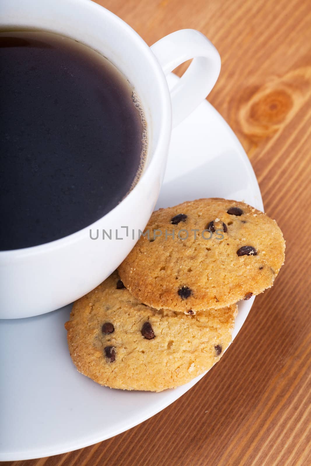 Cup of coffee with cookies on a wooden table