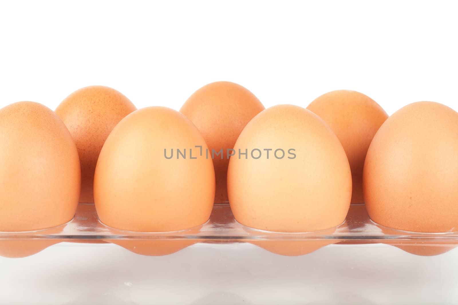 Row of brown eggs isolated over white background