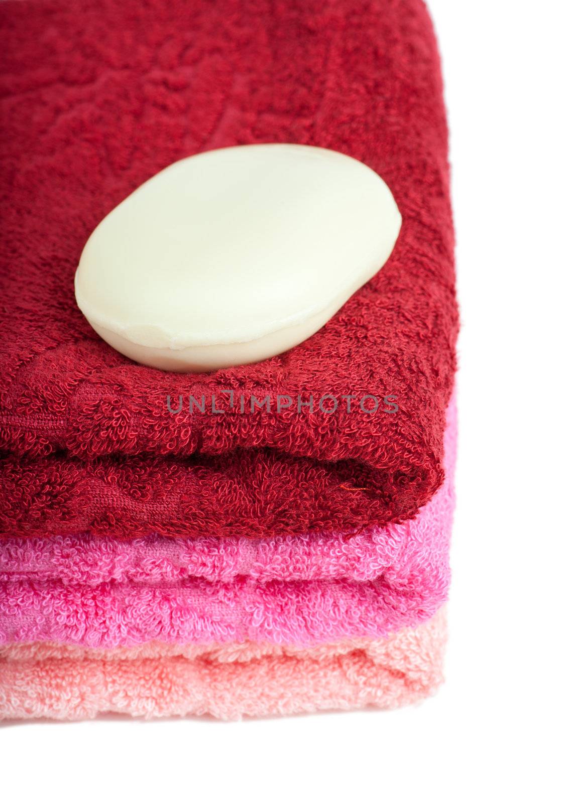 Stack of bright red and pink towels over white background