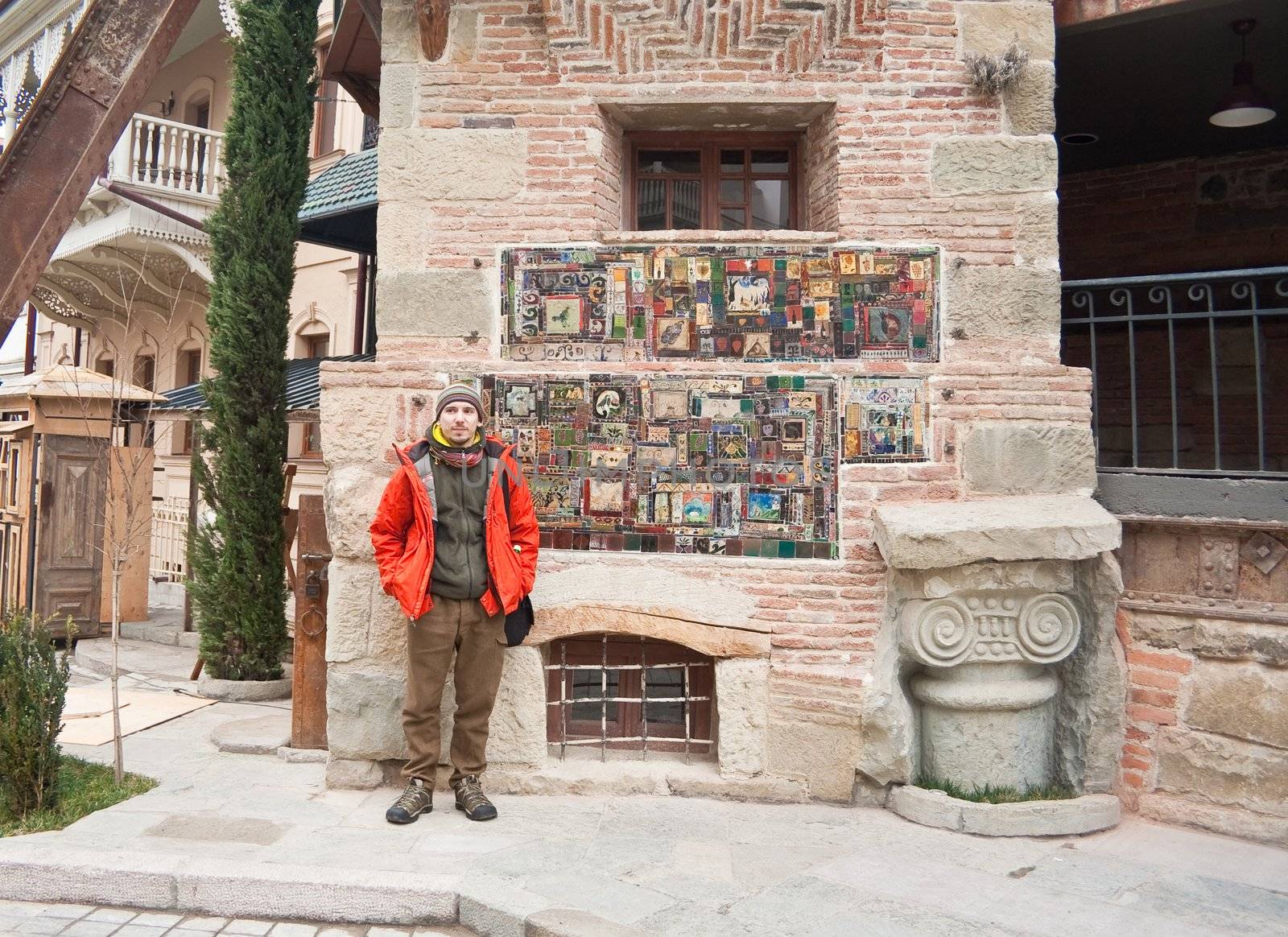 Tourist on the background of the clock tower of the theater puppets Rezo Gabriadze.Tbilisi, Georgia