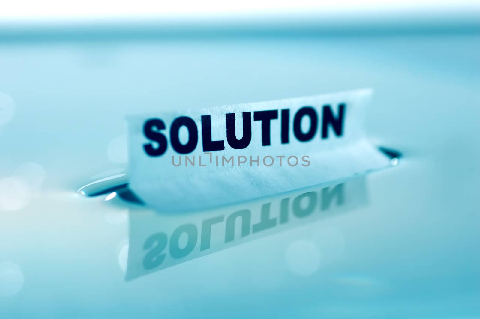 Card floating on water surface with printed word: SOLUTION