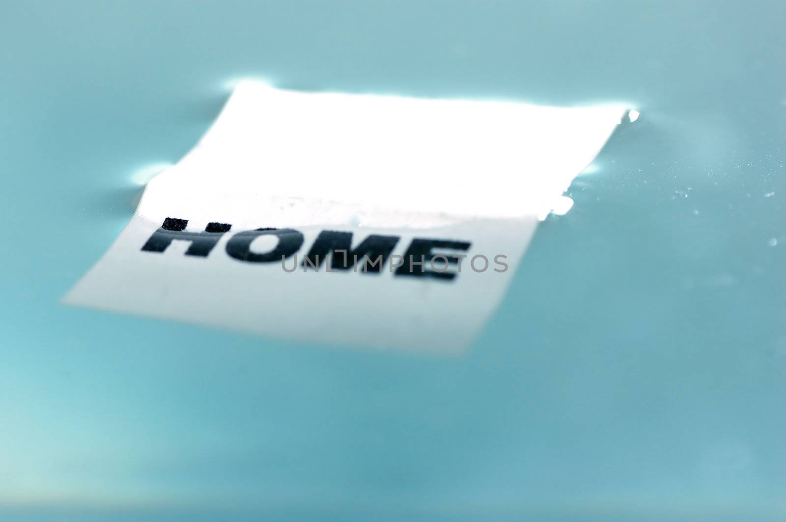 Card floating on water surface with printed word: HOME