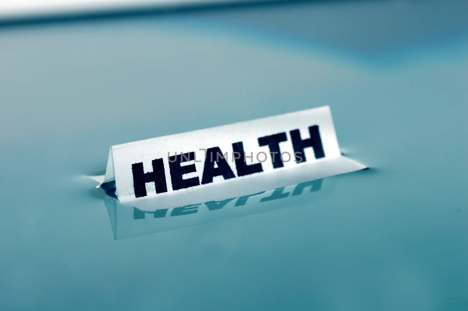 Card floating on water surface with printed word: HEALTH