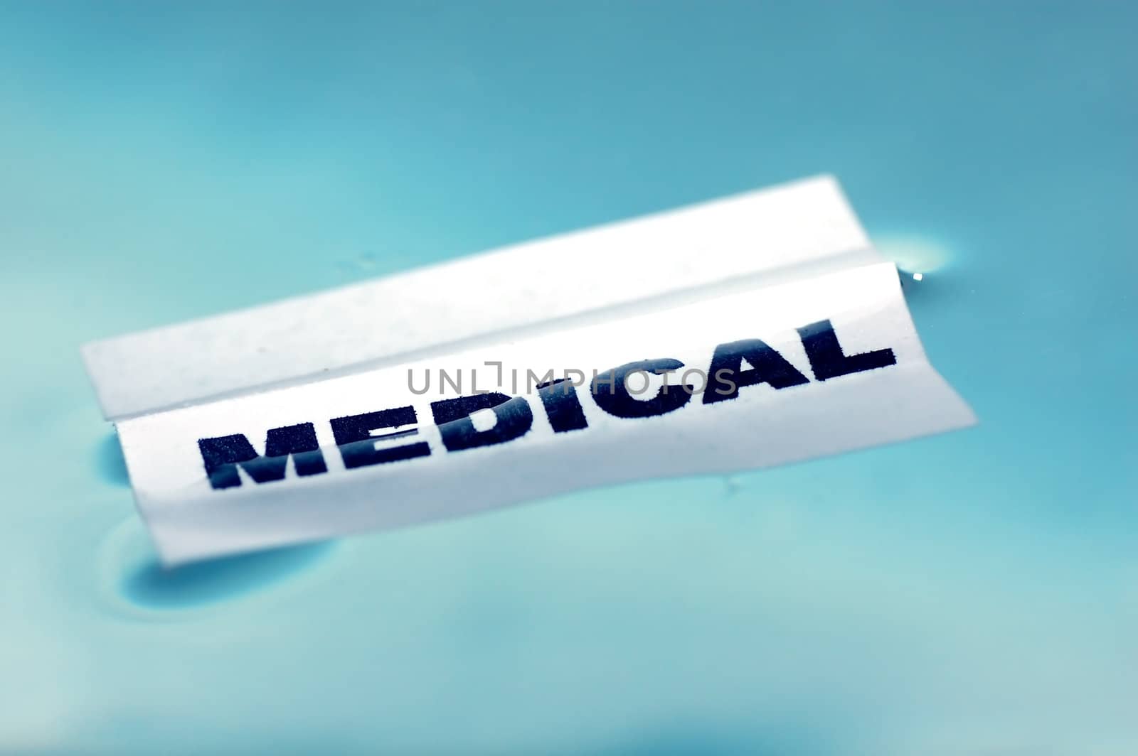 Card floating on water surface with printed word: MEDICAL