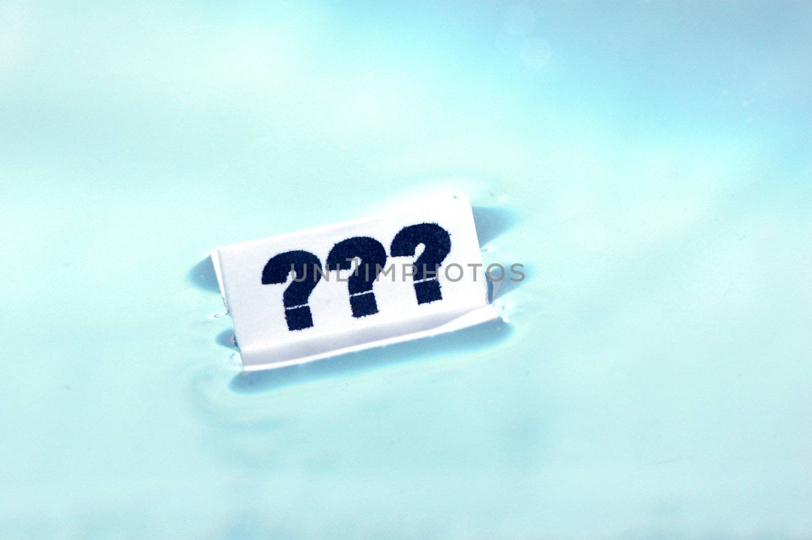 Card floating on water surface with printed: ???