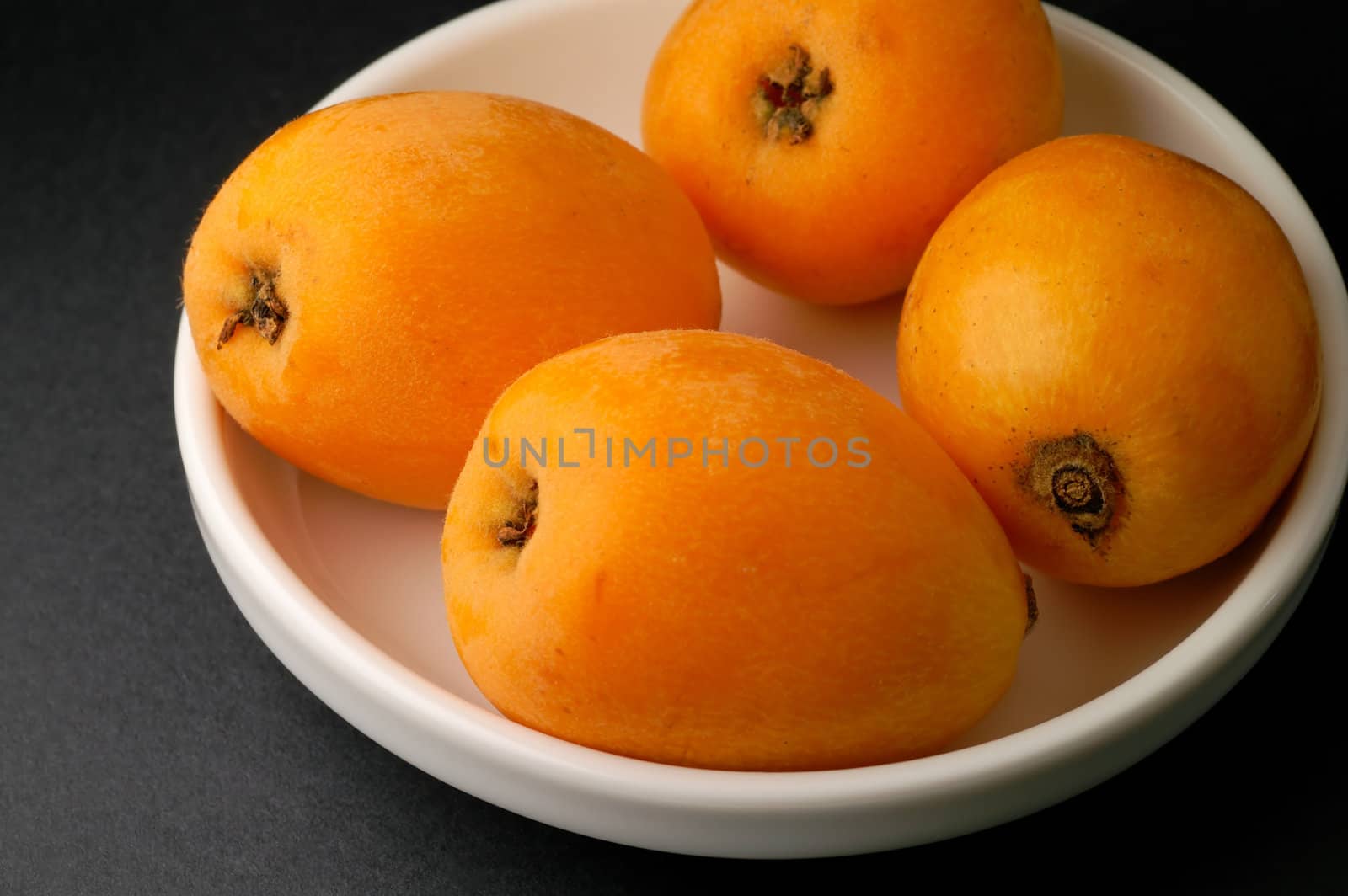Loquats in bowl closeup  by Laborer