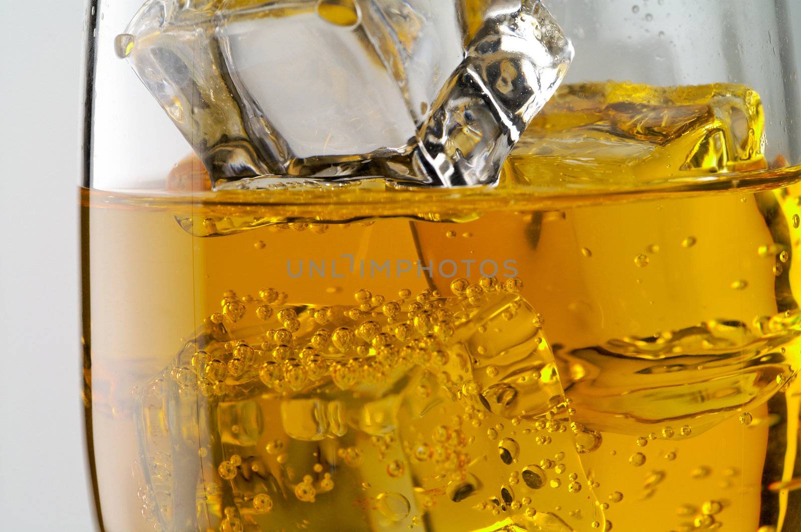 Glass of yellow drink with ice closeup (C2)