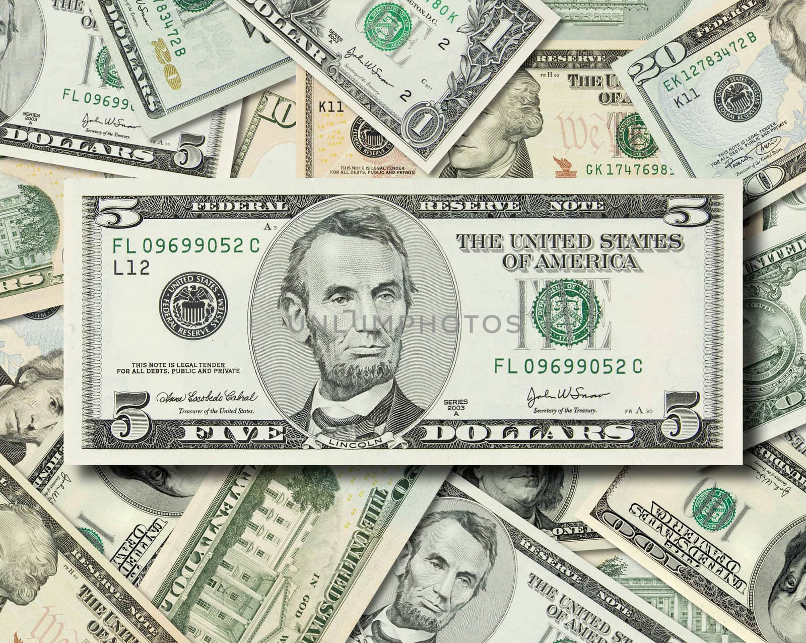 Composite shot of different American Dollar bills piled together with Lincoln's 5 dollar bill in front.