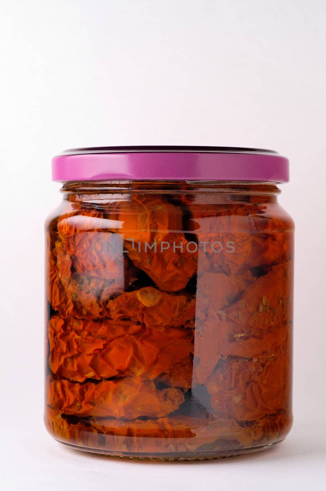 Glass jar of preserved tomatoes  by Laborer