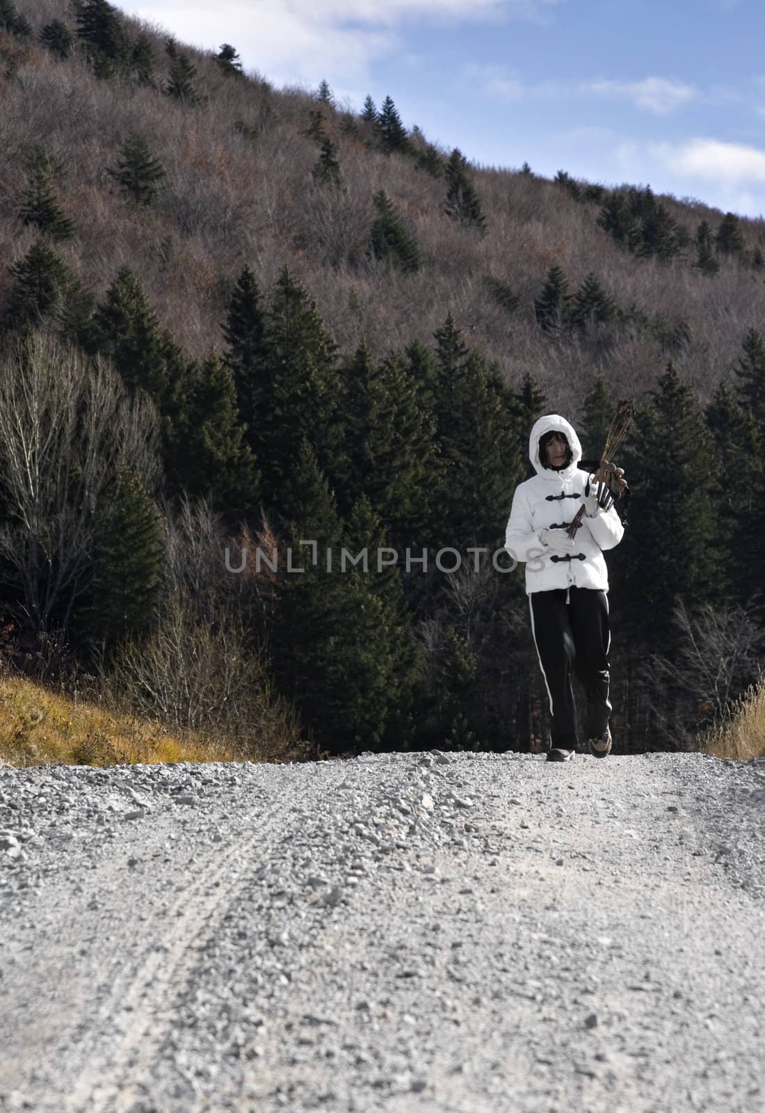 Woman hiking on a country road by domencolja
