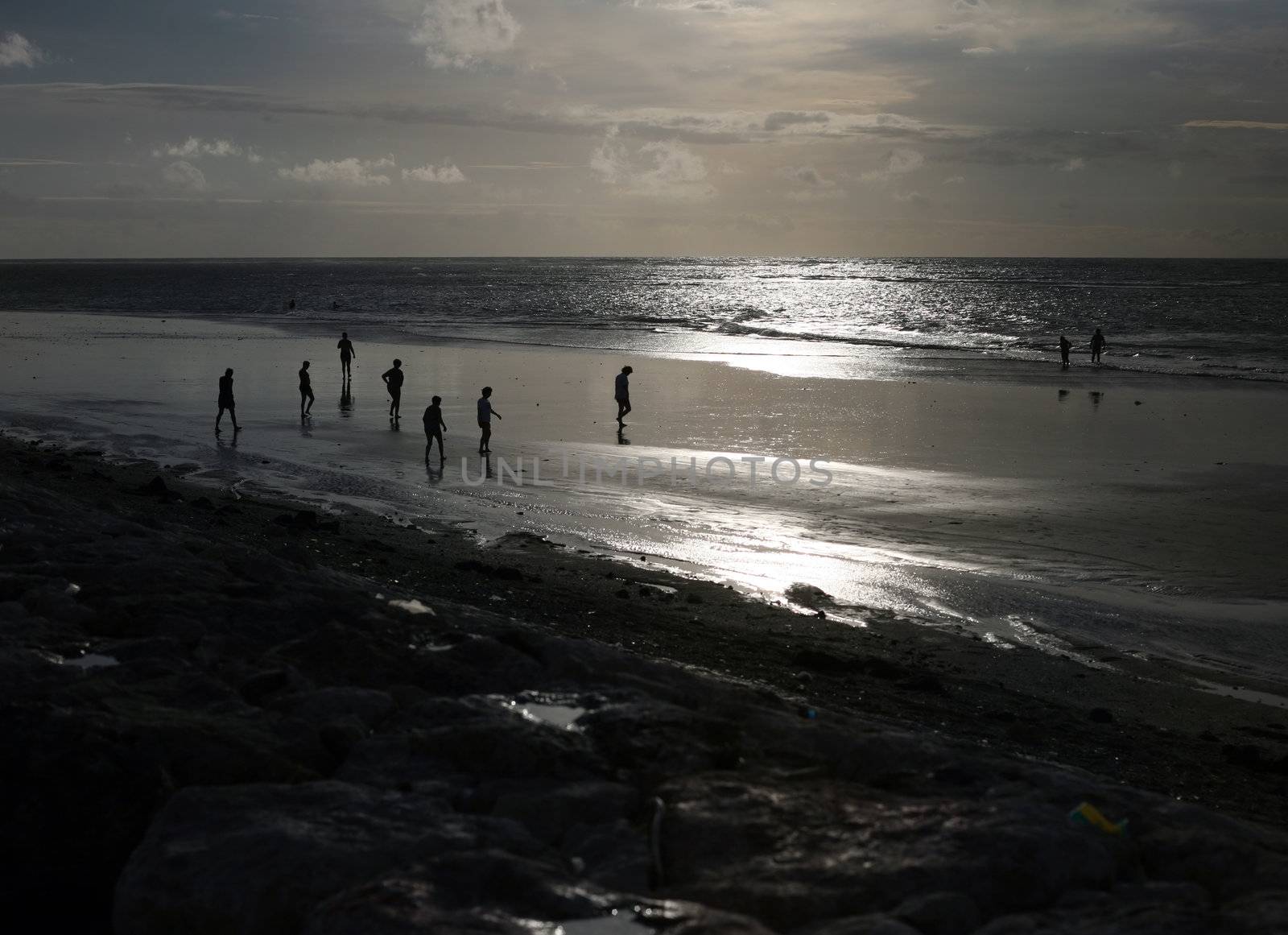 Silhouettes of people on an evening beach. Bali. Indonesia