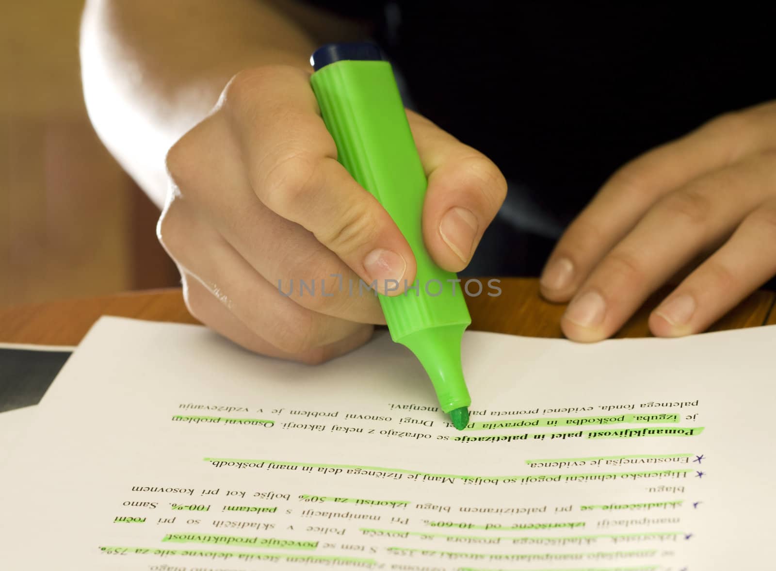 Hands of a student using a green marker on school/university notes.

Lit with three Speedlites: two bulbed ambient ones and a backlight.