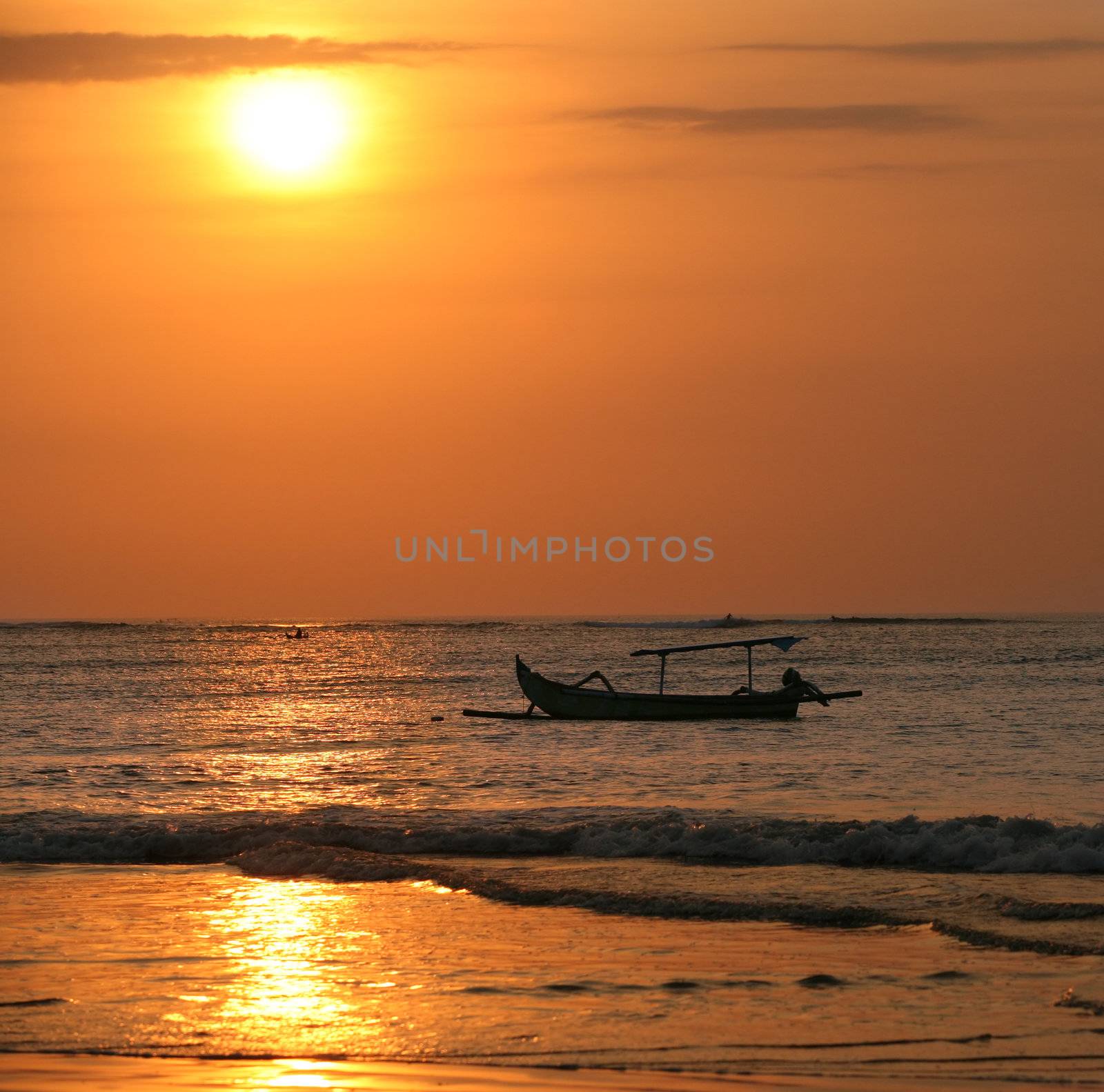 Drifting boat on a sunset. Coast of the Indian ocean. Bali