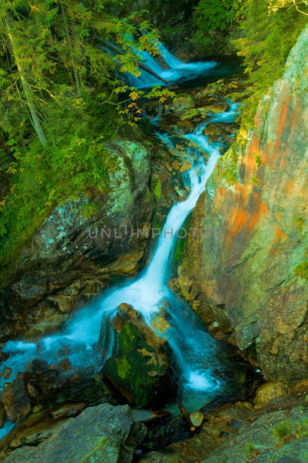 Waterfall in mountains by photocreo