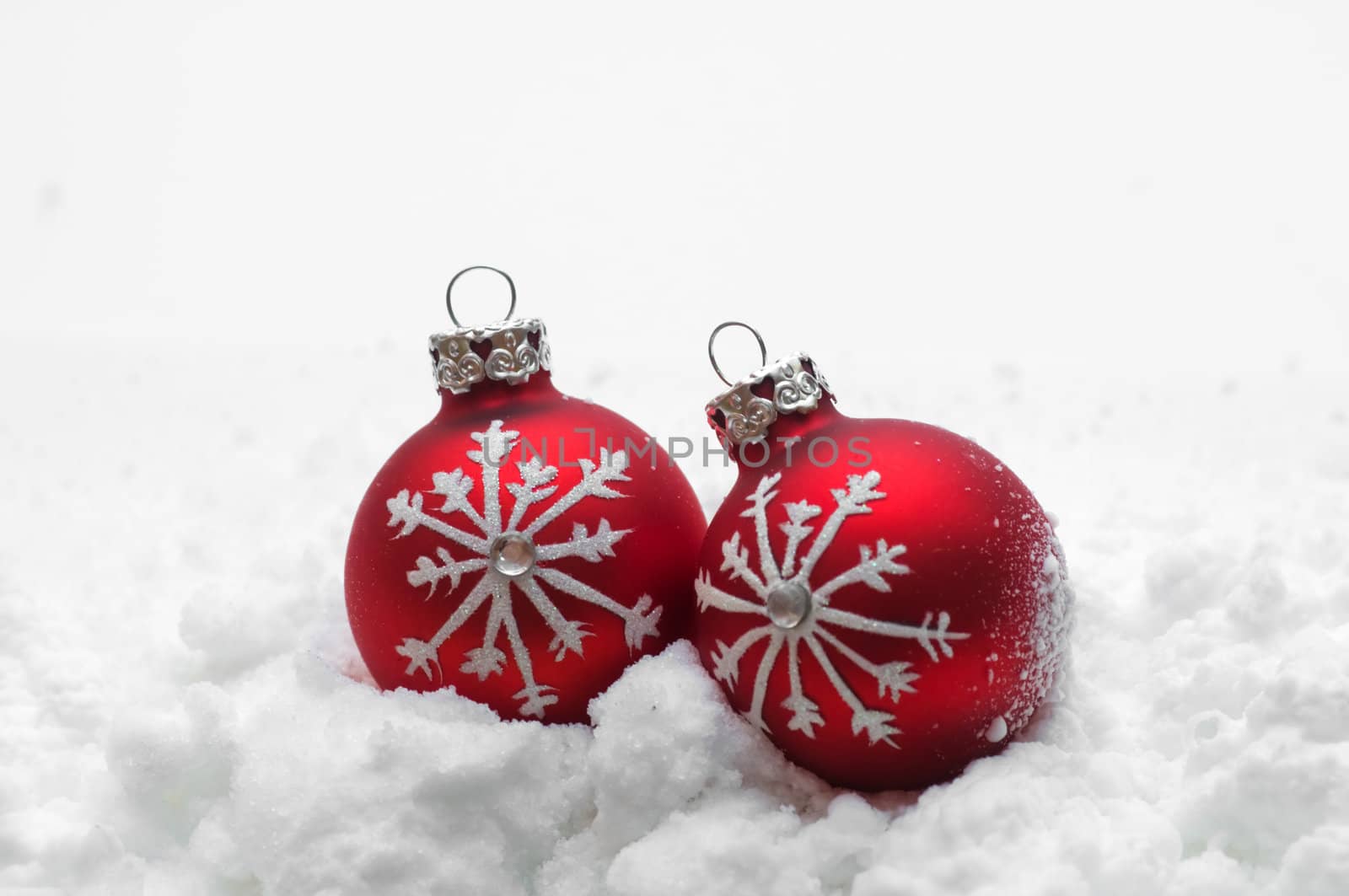 Red Christmas balls in snow on white background