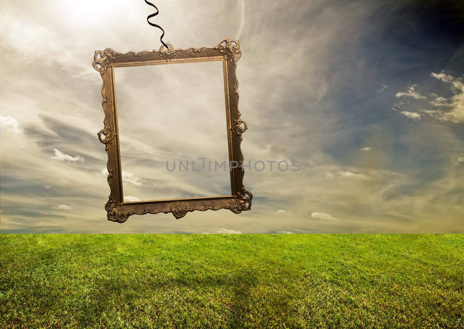 Empty retro frame hanging on poor grassy land. Conceptual.