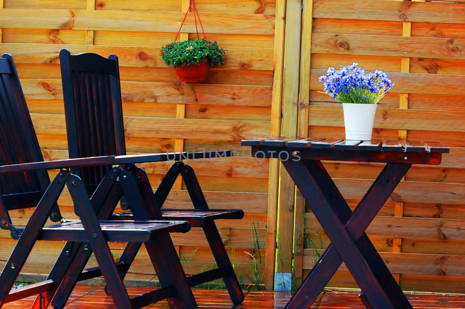 Outdoor design composed with wooden furniture and flowers