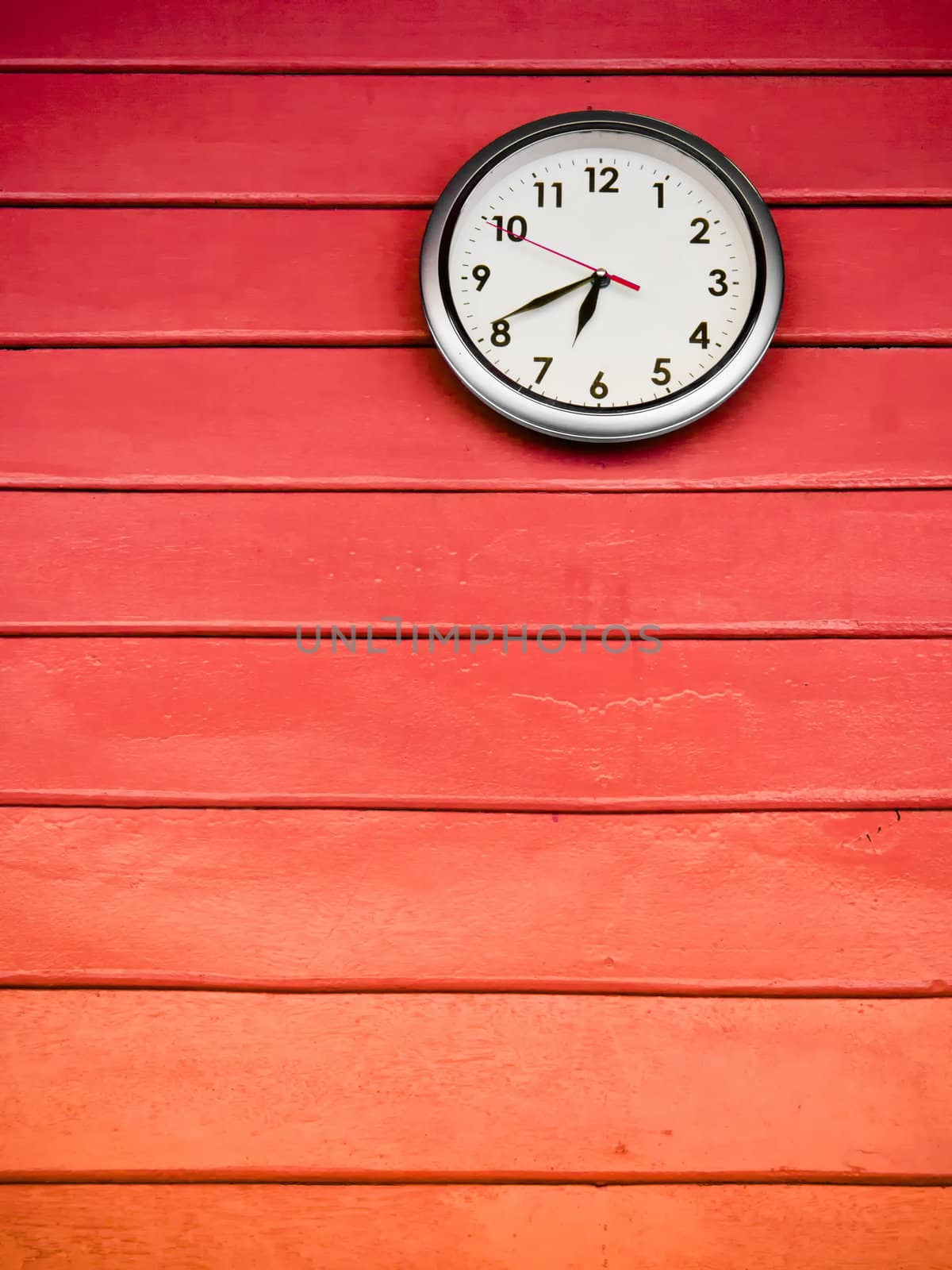 Round white clock Hanging on red wood wall 