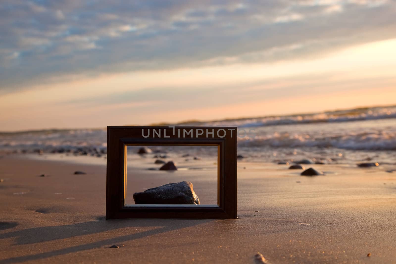 Frame on the beach at sunset. Conceptual, memories from holidays.