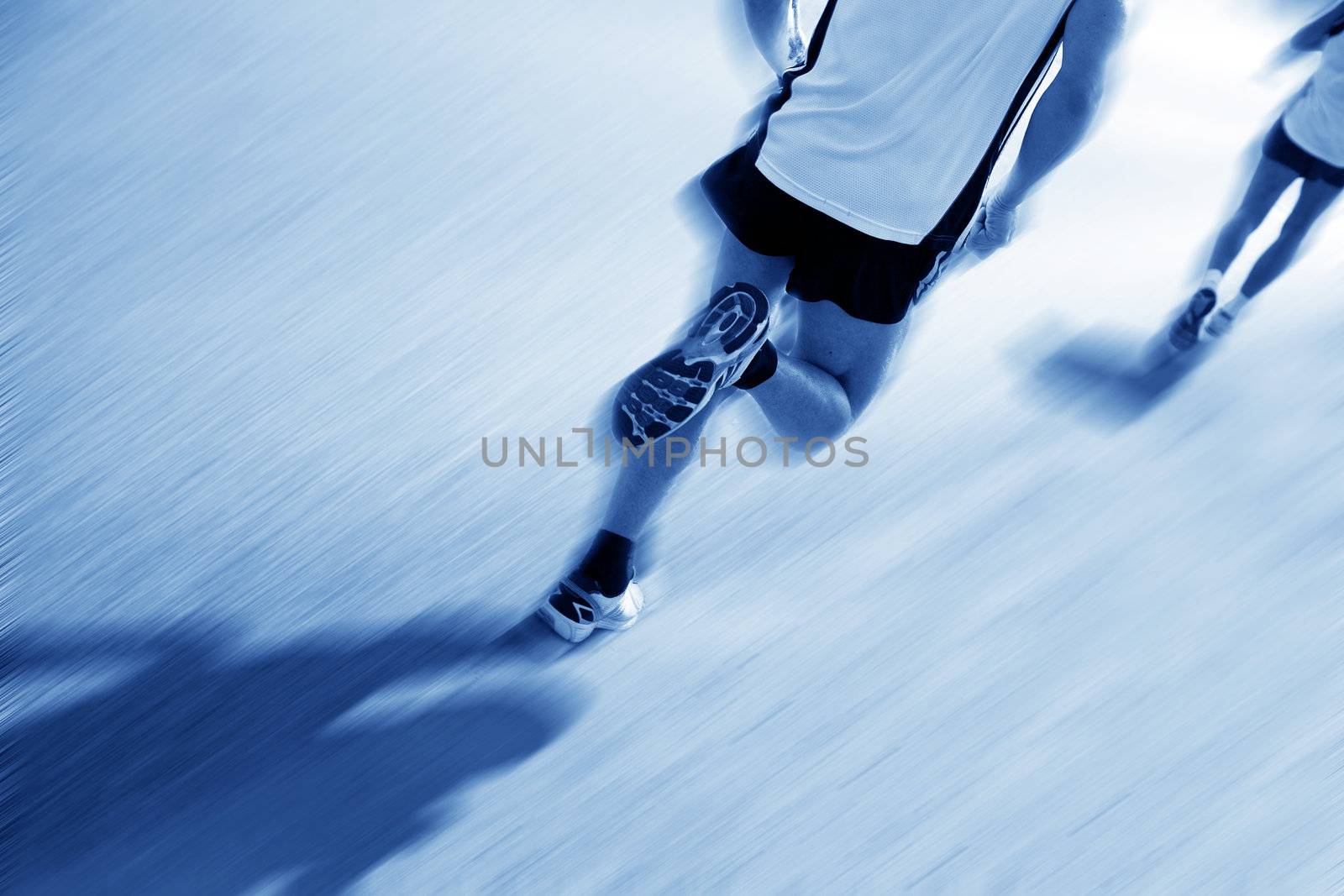Two runners moving fast. Workout, sport, exercise. Motion blur