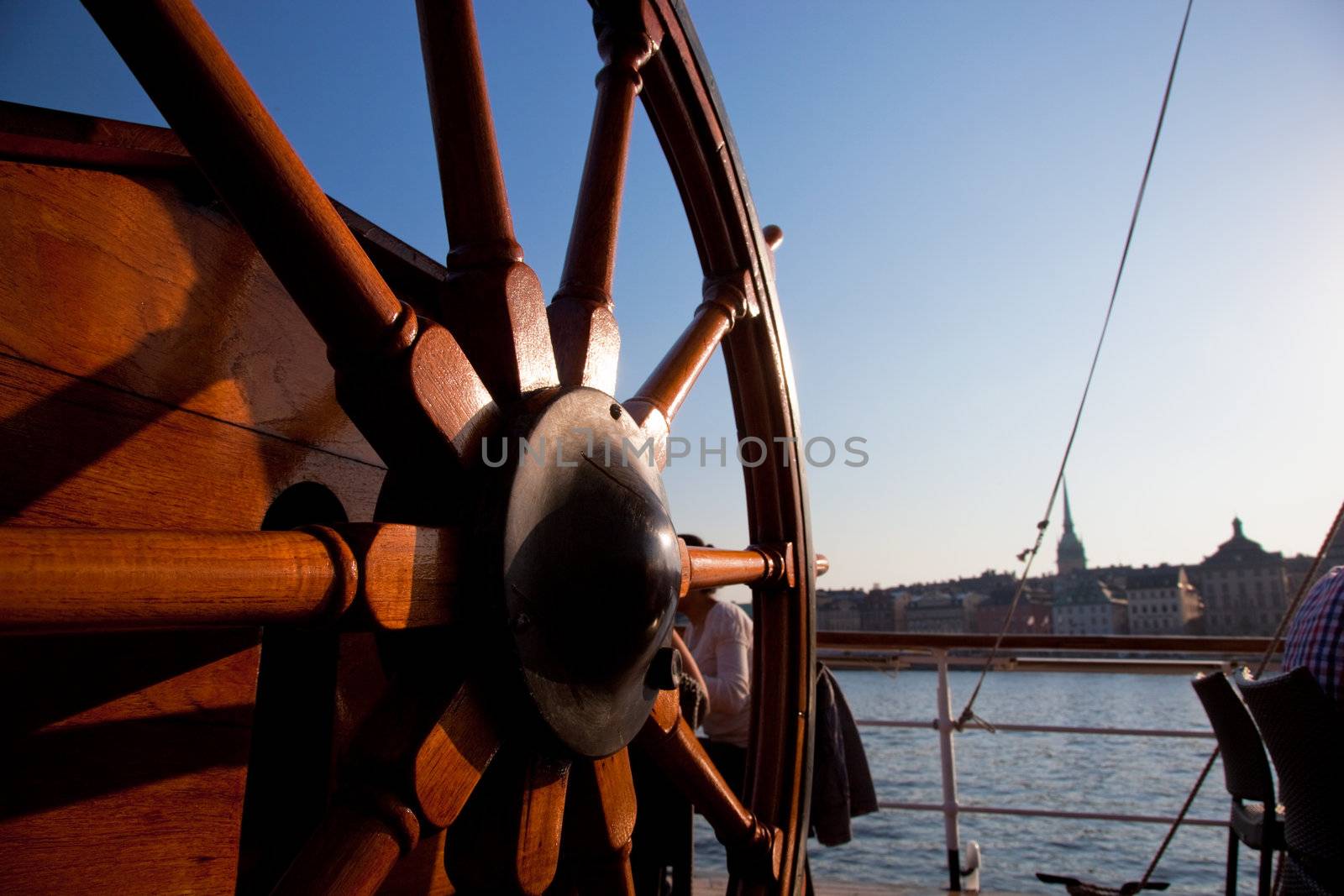 An old, wooden ship helm and a view on Stockholm, Sweden