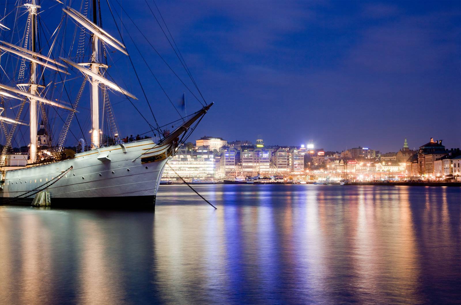 Ship at night in Stockholm, Sweden. City reflections in water