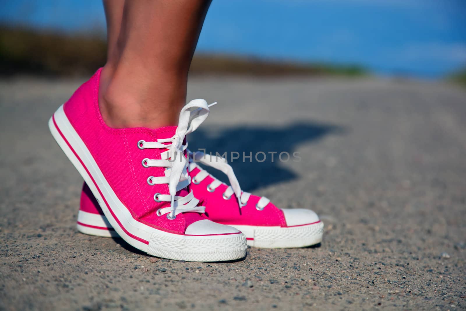 Pink sneakers on girl, young woman legs, outdoors