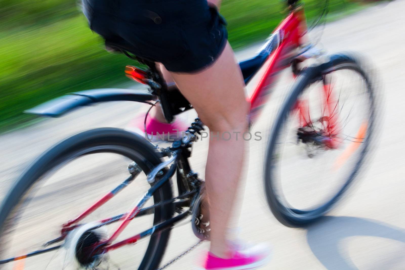 Active woman on a bike trip during summer. Lens blur