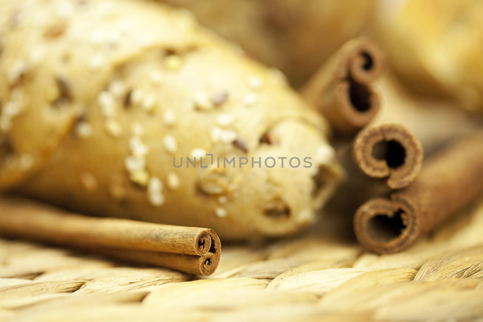 bread and cinnamon sticks on a wicker mat by jannyjus