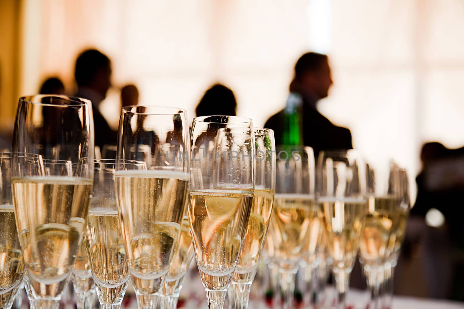 Champagne glasses at the party. People celebrate in the background