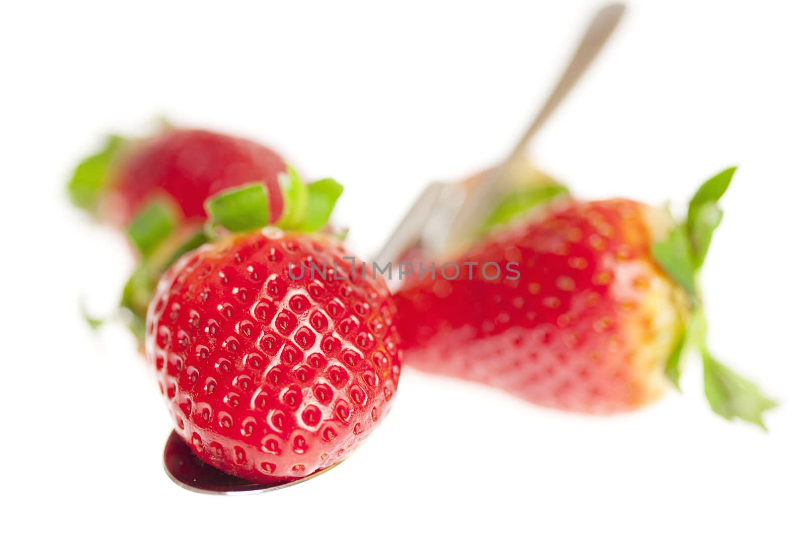juicy strawberries on spoon isolated on white by jannyjus