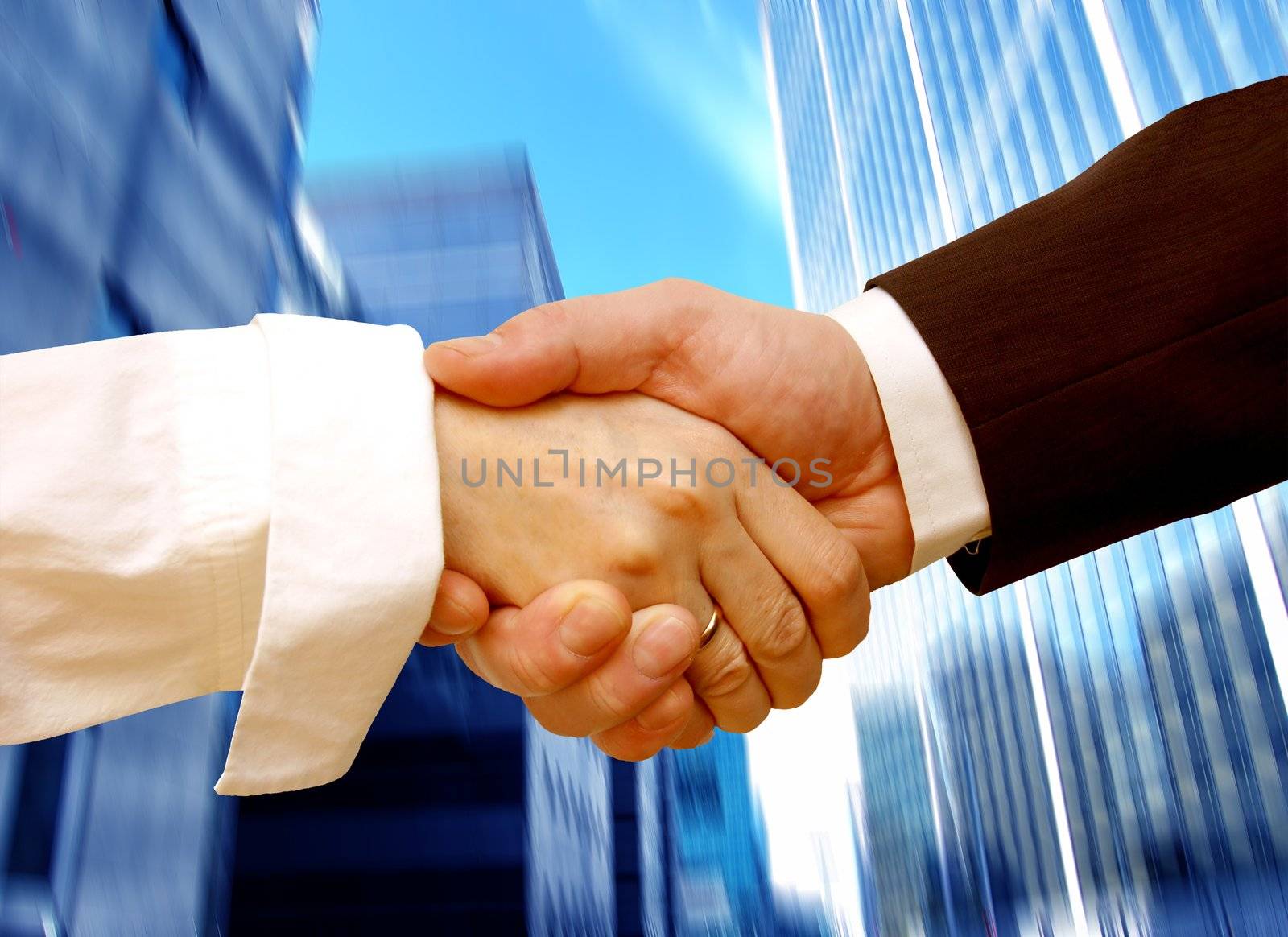 Business handshake on abstract skyscrapers background