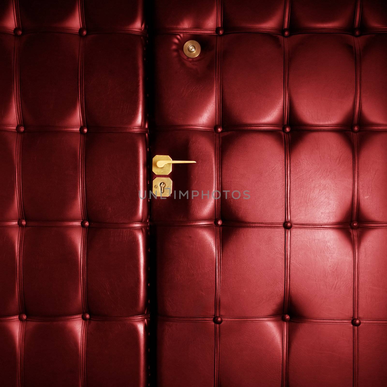 Luxury shining red leather door in retro style with golden handle. Conceptual background