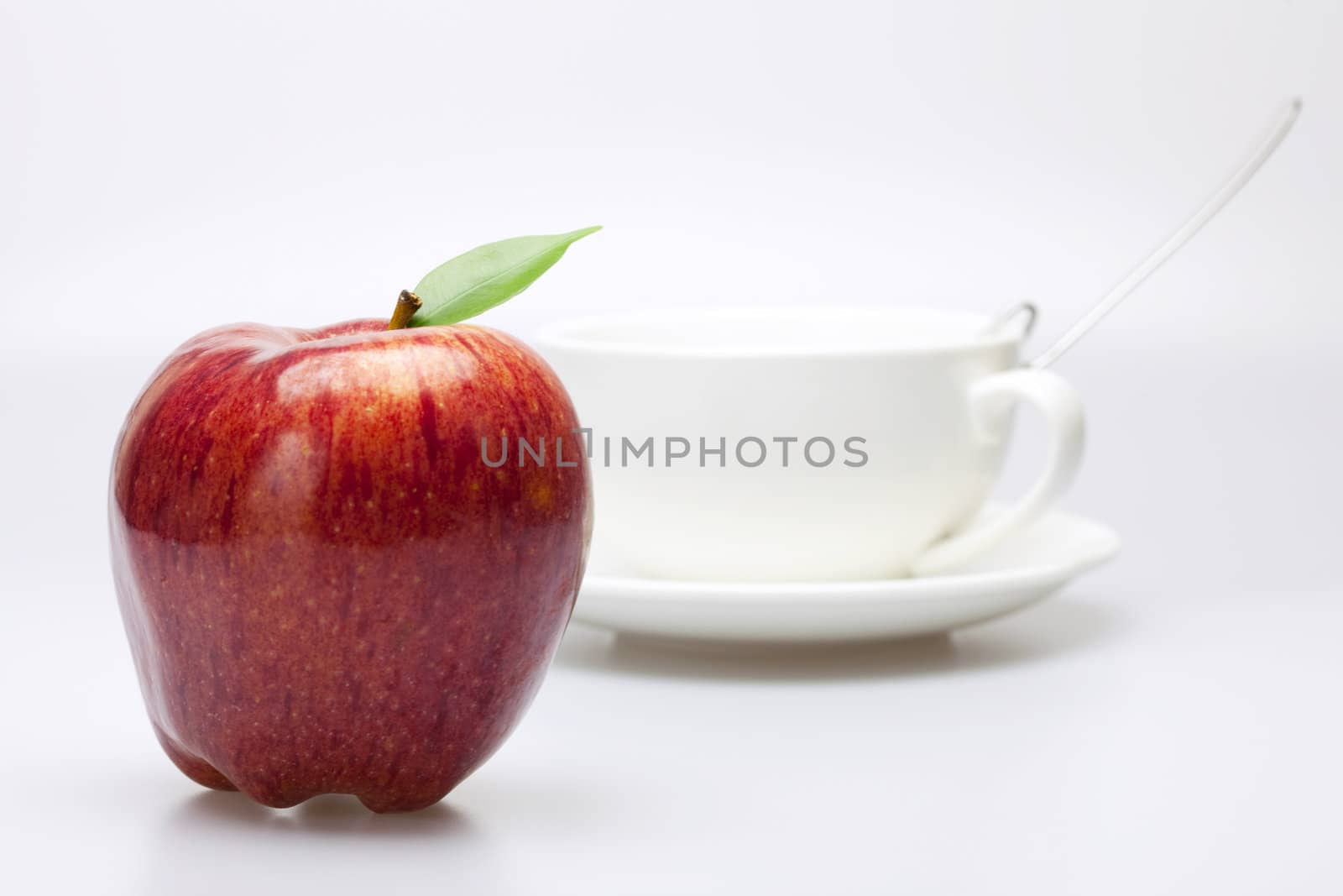 apple and a cup isolated on white by jannyjus