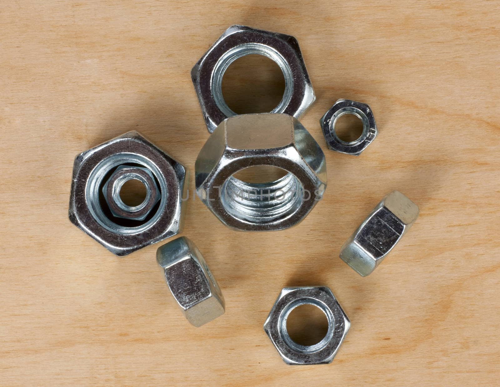 metal nuts on a wooden board
