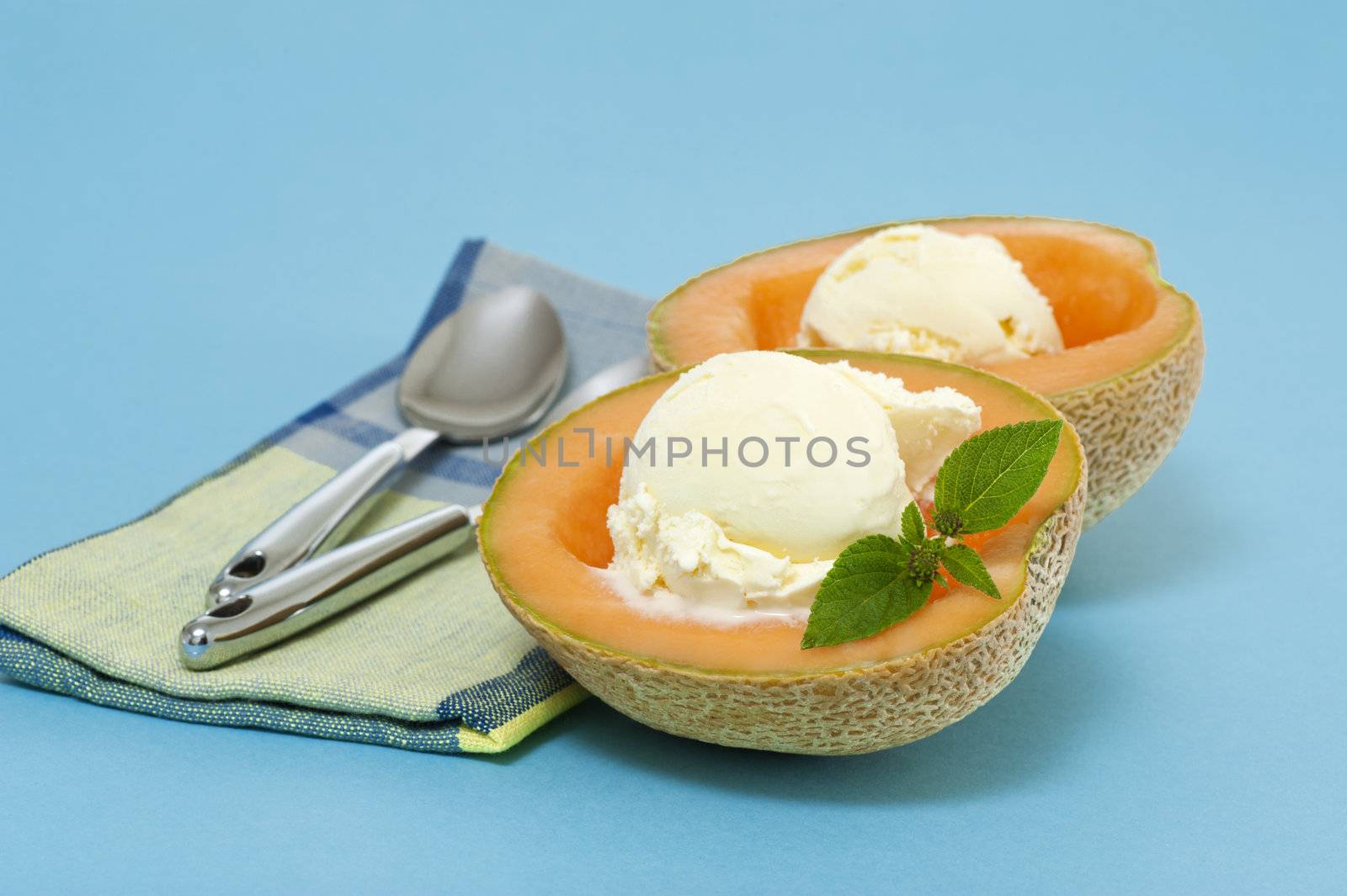 Cantaloupe halves filled with vanilla ice cream.