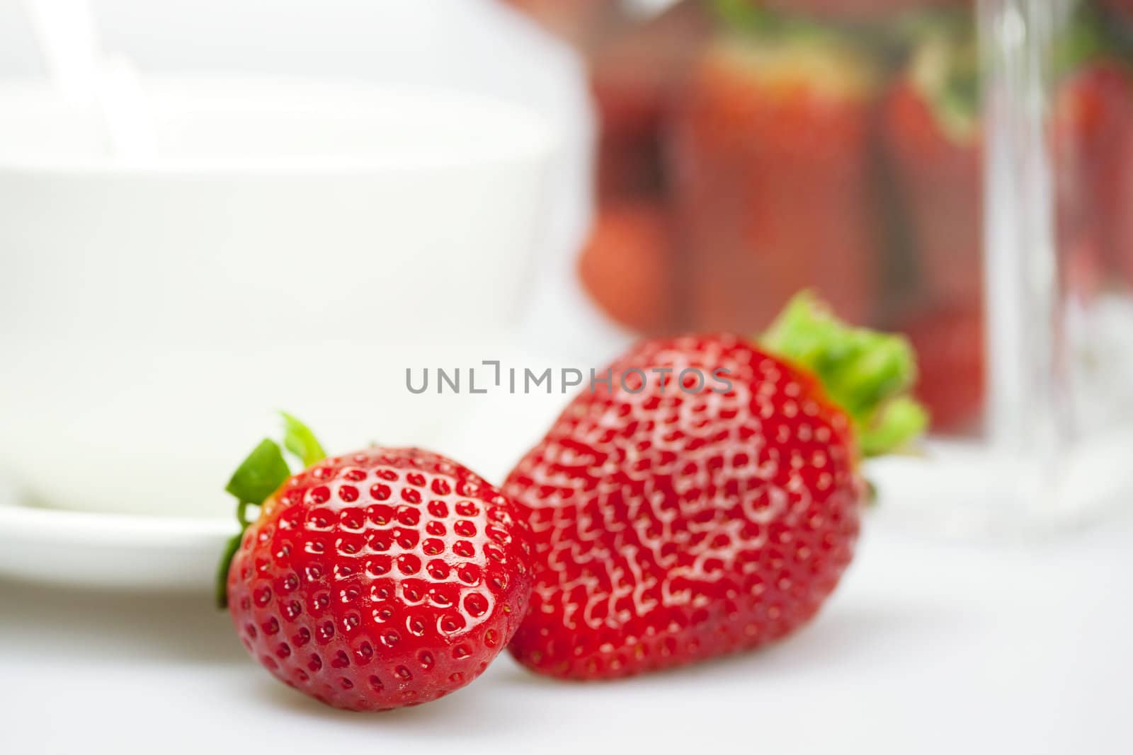juicy strawberries and a cup of white isolated on white