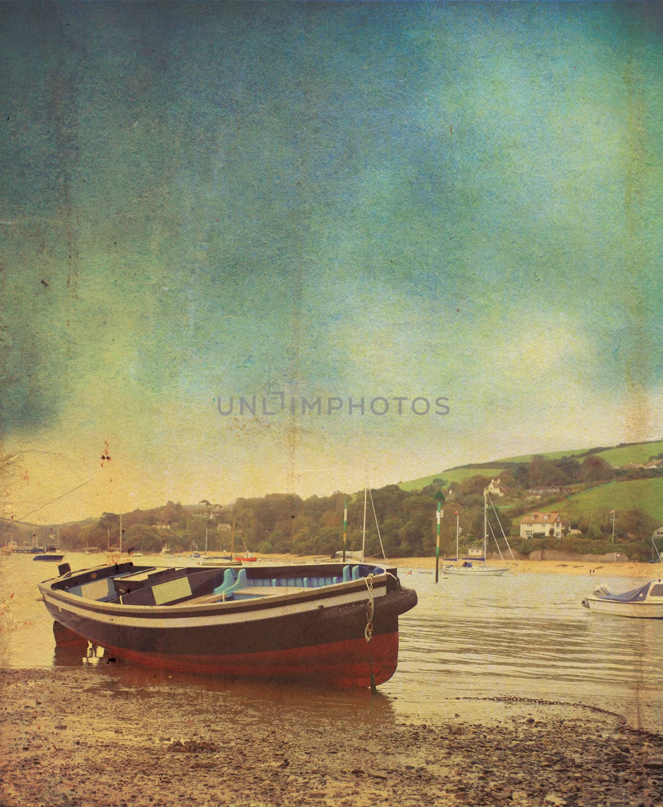 A small wooden ferry boat at low tide at salcombe in devon. A vintage or grunge style effect has been applied. set on a portrait format with room for copy above.