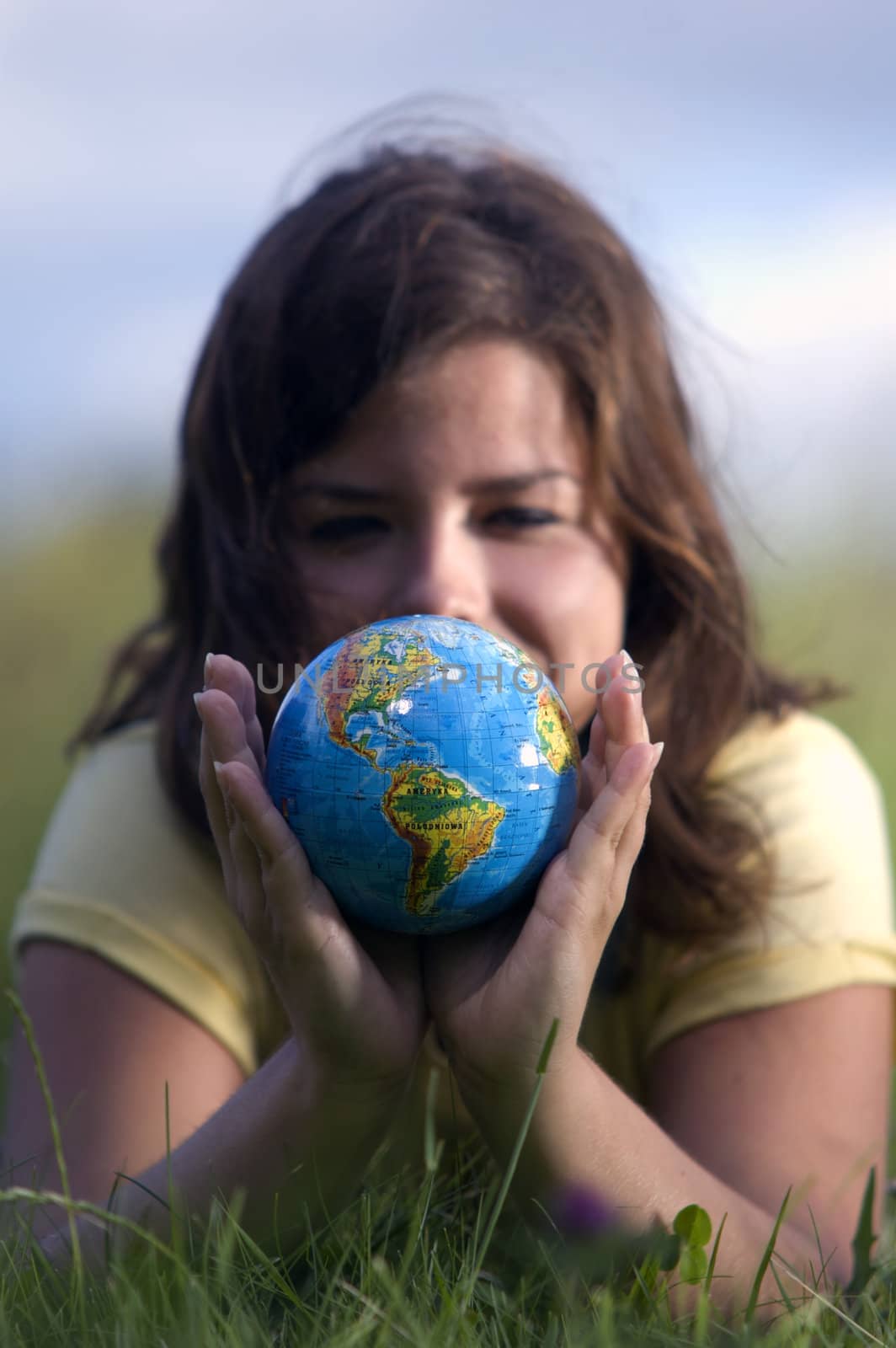 Pretty teen girl watching Earth globe. Conceptual image