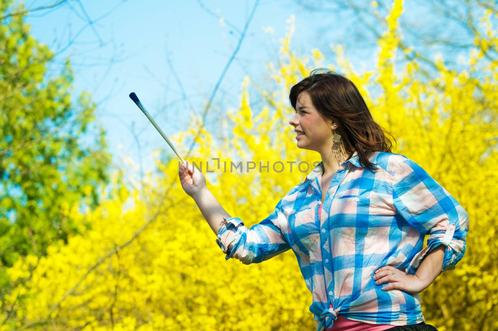 Painting the world. Smiling girl with a paintbrush